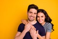 Photo of loving nice cute glad cheerful beautiful couple with girl hugging guy while isolated with yellow background