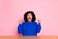 Photo of lucky excited lady dressed sweater sitting table rising fists screaming yes isolated pink color background Royalty Free Stock Photo