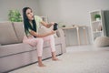 Photo of mad young girl sit couch hold joystick open mouth barefoot wear green t-shirt pink pants indoors