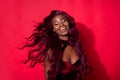 Photo of magnificent happy afro american young lady fly hair blow wind glamour isolated on red color background