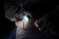 Camper in gloves using green tactical led flashlight Royalty Free Stock Photo