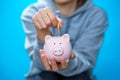 Photo of male throwing coin into piggy bank Royalty Free Stock Photo