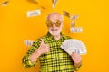 Photo of man happy positive smile show thumb-up cool like fine money cash rich dollars fly air isolated over yellow Royalty Free Stock Photo