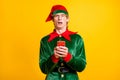 Photo of man hold cellphone puzzled upset face look camera wear elf velvet green costume headwear specs isolated yellow