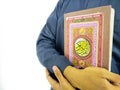 Photo of man holding a Koran ready for Ramadan.  Arabic on the cover is translated as the Qur`an Royalty Free Stock Photo