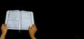 Photo of man holding a Koran ready for Ramadan. Arabic on the cover is translated as the Qur`an