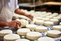 Photo of a man kneading cheese pastries in an apron. Industrial cheese production plant. Modern technologies. Production of Royalty Free Stock Photo