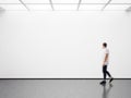 Photo of man in modern gallery looking at the empty canvas. Blank mockup, motion blur Royalty Free Stock Photo