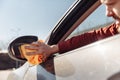 Photo of man with orange rag washing distant-looking car mirror. Royalty Free Stock Photo