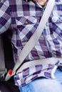 Photo of man in plaid shirt sitting in a car putting on seat belt Royalty Free Stock Photo