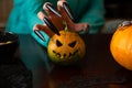Photo of man`s hands with pumpkin jack sitting at wooden table