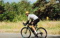 Photo of a man in sports outfit rides a bike on a forest road on a sunny day, side view Royalty Free Stock Photo