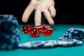 Photo of man throwing dice on table with chips in casino