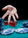 Photo of man throwing red dice on table with chips in casino Royalty Free Stock Photo