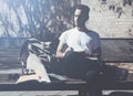 Photo man wearing white tshirt sitting city park and writes message. Studying at the University, working project. Books Royalty Free Stock Photo