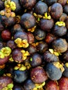 photo of mangosteen displayed in a traditional market basket