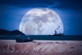 Photo Manipulation. Fishing boat parked on beach and cargo ship anchored in the sea Royalty Free Stock Photo