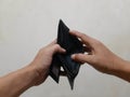 Photo of a mans hand opening a black wallet with no money Royalty Free Stock Photo