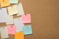 Photo of many pile lot of colorful stickers and torn paper from notepad attached with pins to the wooden board Royalty Free Stock Photo