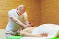Photo of masseur performing traditional Thai massage on woman back in the spa salon. Beauty treatment concept Royalty Free Stock Photo