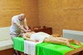 Photo of masseur performing traditional Thai massage on woman back in the spa salon. Beauty treatment concept Royalty Free Stock Photo