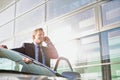 Portrait of mature attractive businessman talking on smartphone while standing outside the car Royalty Free Stock Photo