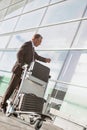 Portrait of mature businessman checking time on his watch while waiting in the airport Royalty Free Stock Photo