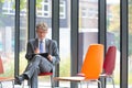 Photo of mature businessman sitting while writing on document in office Royalty Free Stock Photo