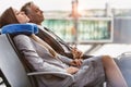 Mature businessman and young attractive businesswoman sleeping while waiting for boarding in their gate at airport Royalty Free Stock Photo