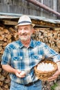 Mature farmer wearing hat while carrying fresh eggs in basket at barn Royalty Free Stock Photo