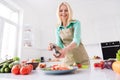 Photo of mature woman happy positive smile prepare meal cooking flavoring pepper spices tasty plate kitchen home