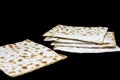 A photo of two pieces of matzah or matza isolated on black background. Matzah for the Jewish Passover holidays. Place for text, co