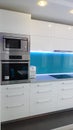 Photo of mid size kitchen apartment in turquoise colours, leather modern and minimalist seater, white dining table for six persons