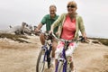 Portrait of middle aged Couple Riding Bikes along Beach Royalty Free Stock Photo