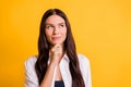 Photo of minded happy woman hold hand chin look empty space think plan isolated on yellow color background