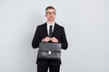 Photo of minded leader marketer guy hold briefcase look empty space isolated over grey color background