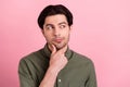 Photo of minded smart man finger chin look empty space wear green shirt isolated pink color background