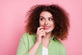 Photo of minded woman with perming coiffure dressed stylish shirt look empty space finger on lips isolated on pink color Royalty Free Stock Photo