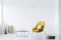 photo of a minimalistic living room interior with a yellow armchair. Empty, white wall. Place your poster