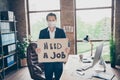 Photo of moody office worker mature guy holding placard poster looking for new job fired bad mood modern office indoors