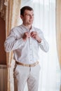 Morning groom. Man buttoning shirt. Vertical photo