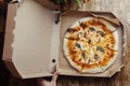 Close-up of Margarita pizza in a disposable dish. Top view of takeaway food in a fast food cafe. On photo - mozzarella cheese, Royalty Free Stock Photo