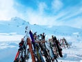 Photo of multi-colored skis in snow at winter resort in afternoon.