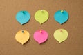 Photo of multicolored pieces of paper in shape of speech bubble attached with pins to the wooden backdrop
