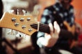 Photo of musician playng on six string fretless bass guitar on the street in front of people.