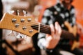 Photo of musician playng on six string fretless bass guitar on the street in front of people.