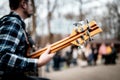 Photo of musician playng on six string fretless bass guitar on the street in front of people.