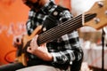 Photo of musician playng on six string fretless bass guitar on the street in front of people.