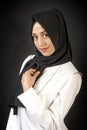 Photo Muslim girl in modern oriental clothes with a scarf on her head, on a dark background