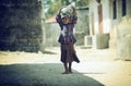 Photo Muslim girl walking barefoot on dervne with baggage on their heads, filmed in Madagascar in October 2014